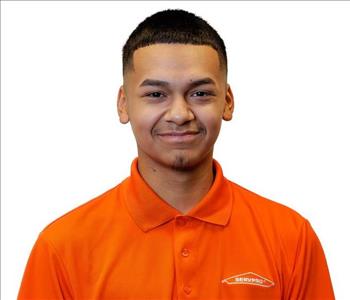 Male employee in SERVPRO shirt in front of a white backdrop
