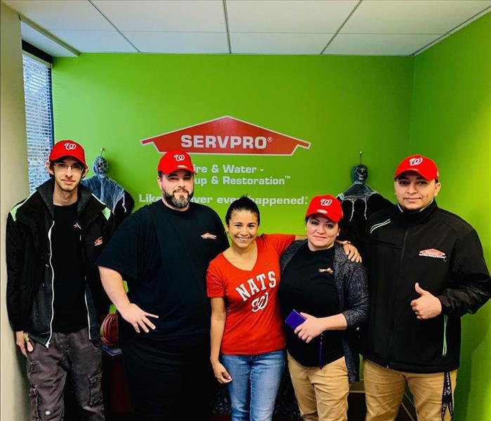 five Servpro workers posing for picture with Washington nationals hats and shirt on